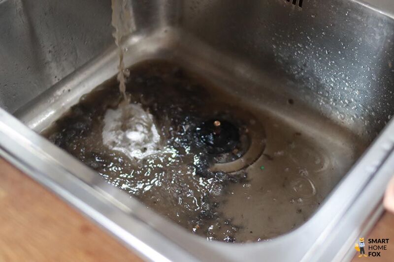 Dirty water from the carpet cleaner being poured down the sink.